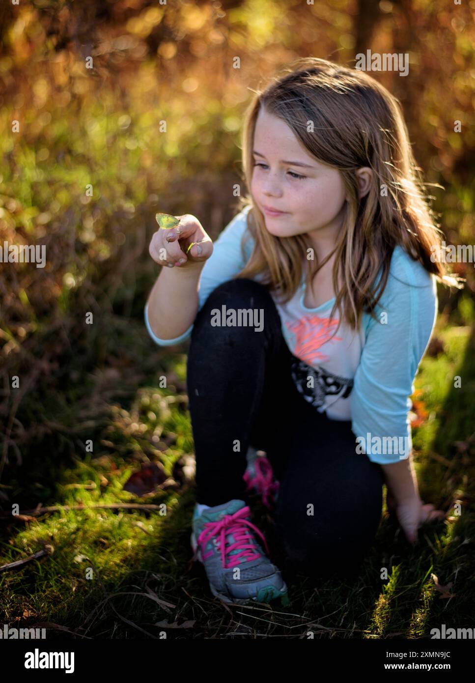 Young girl holding green butterfly on finger Stock Photo