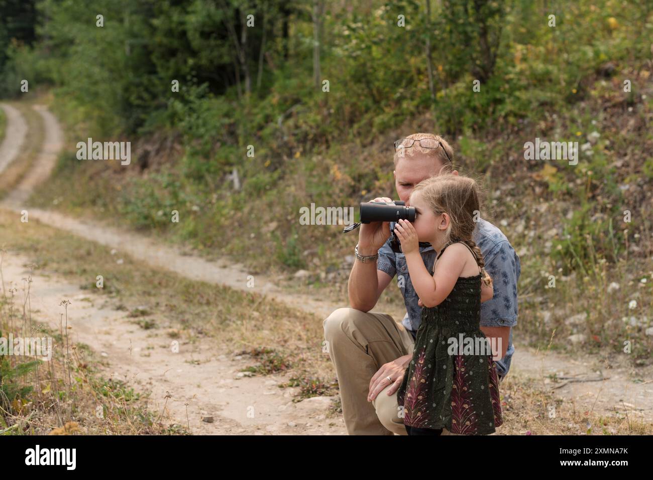 Father teaches young girl how to see through binoculars Stock Photo - Alamy