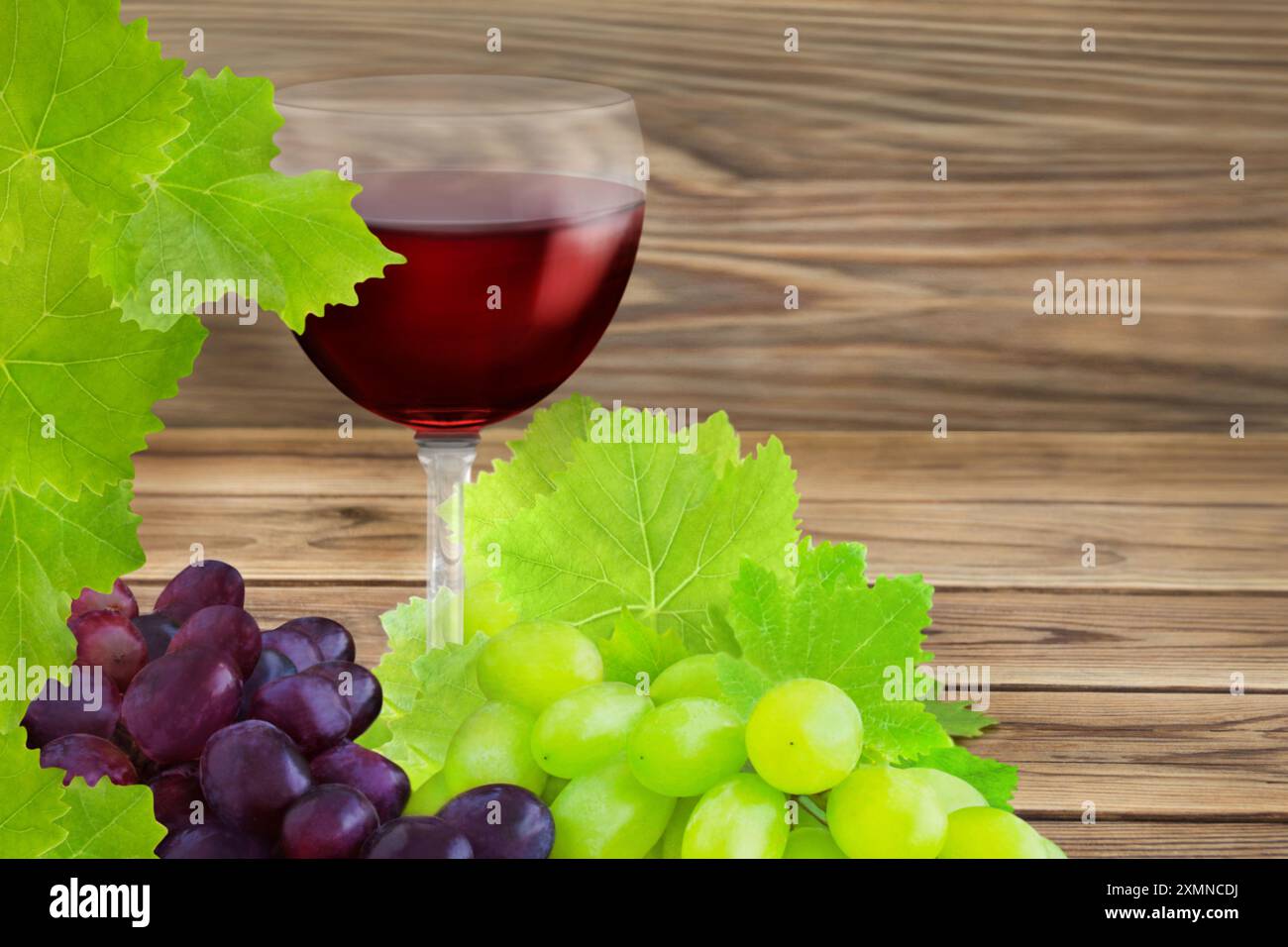 1 Glass of red wine with grapes and vine leaves on wooden background Stock Photo