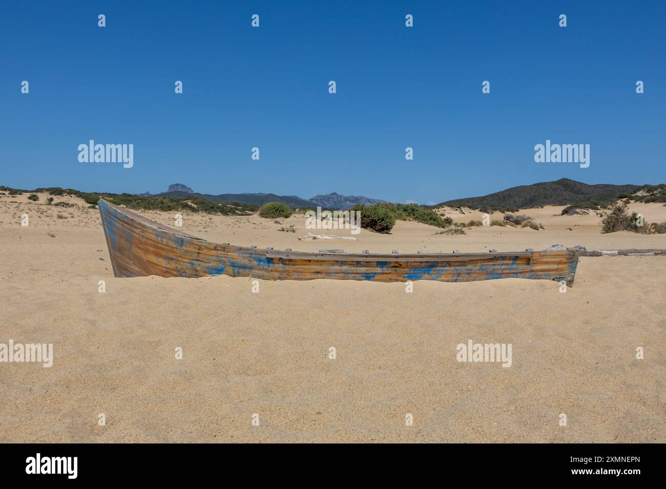 Old wooden boat partially buried in the sand on a deserted beach Stock ...