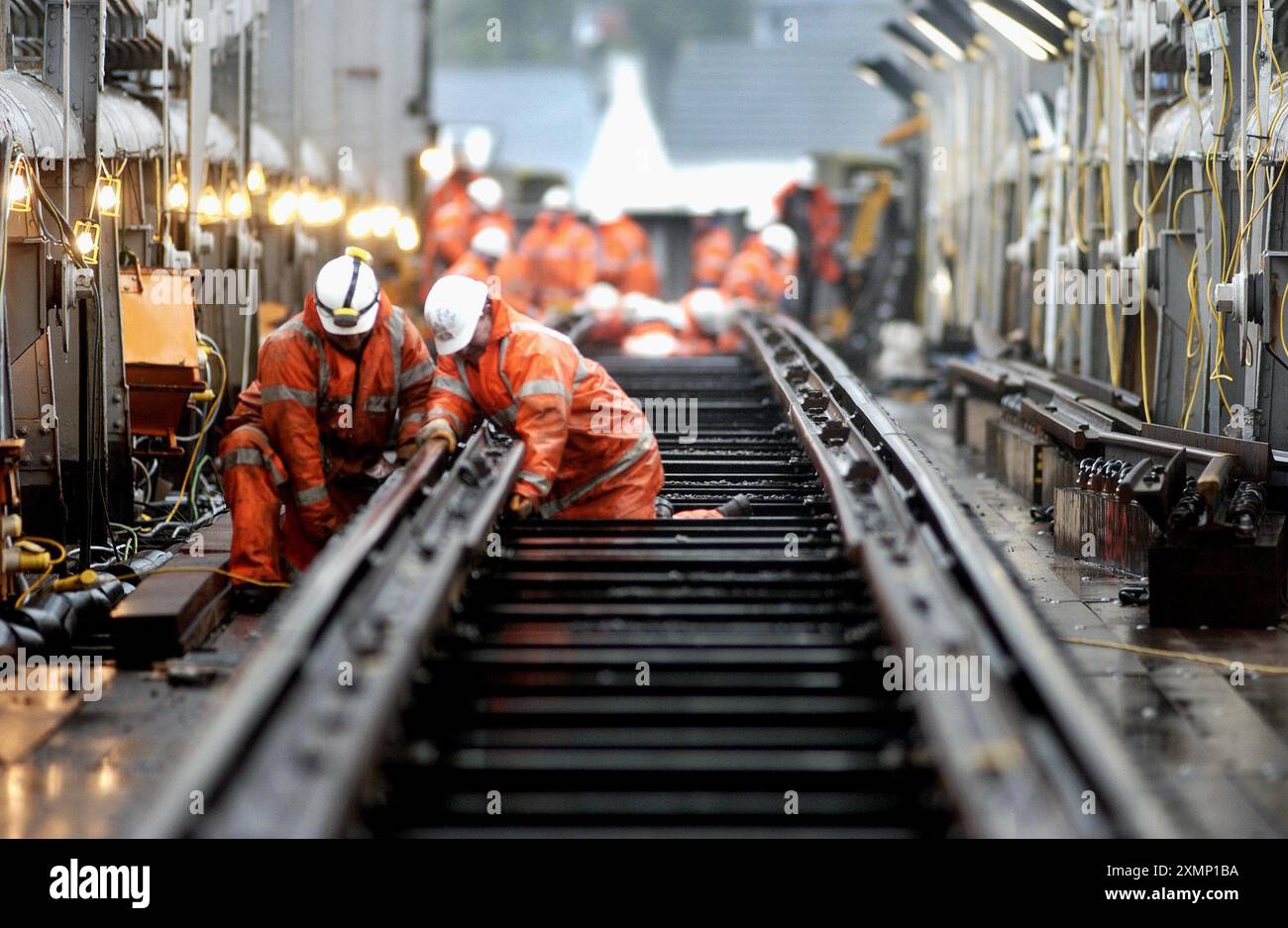 Picture by Roger Bamber: 22 Jan 2003:  A £3 million refurbishment of the Royal Albert Bridge over the Tamar will restore Isambard Kingdom Brunel's original hardwood timber trackbase, originally used from construction in1859 until the 1920s. Engineers found  modern sleepers and ballast trackbeds cause more metal fatigue to the structure. The bridge links Devon and Cornwall. Picture shows Plate Layers John Postgate and John White cheacking the Fixings of the newly laid railson the bridge. Stock Photo