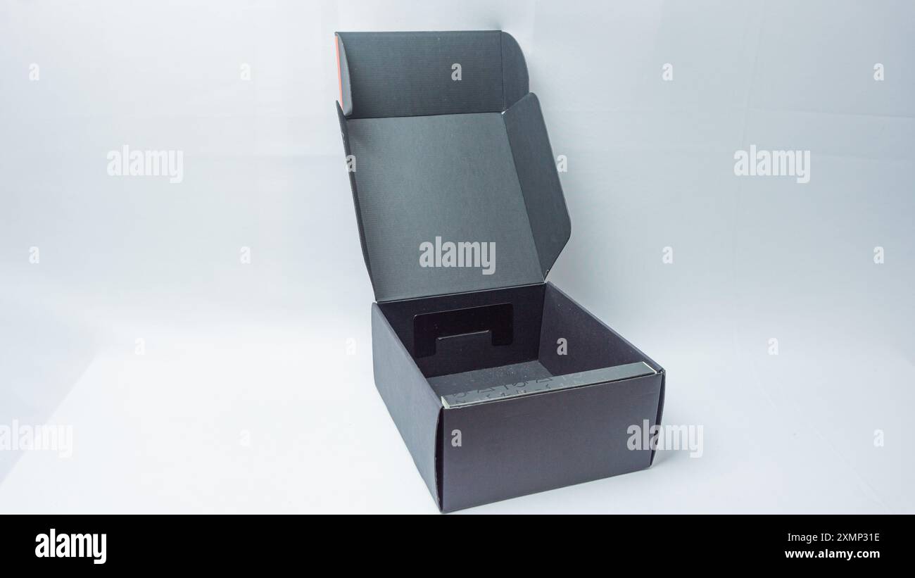 Opened black headset packaging box isolated on black background Stock Photo