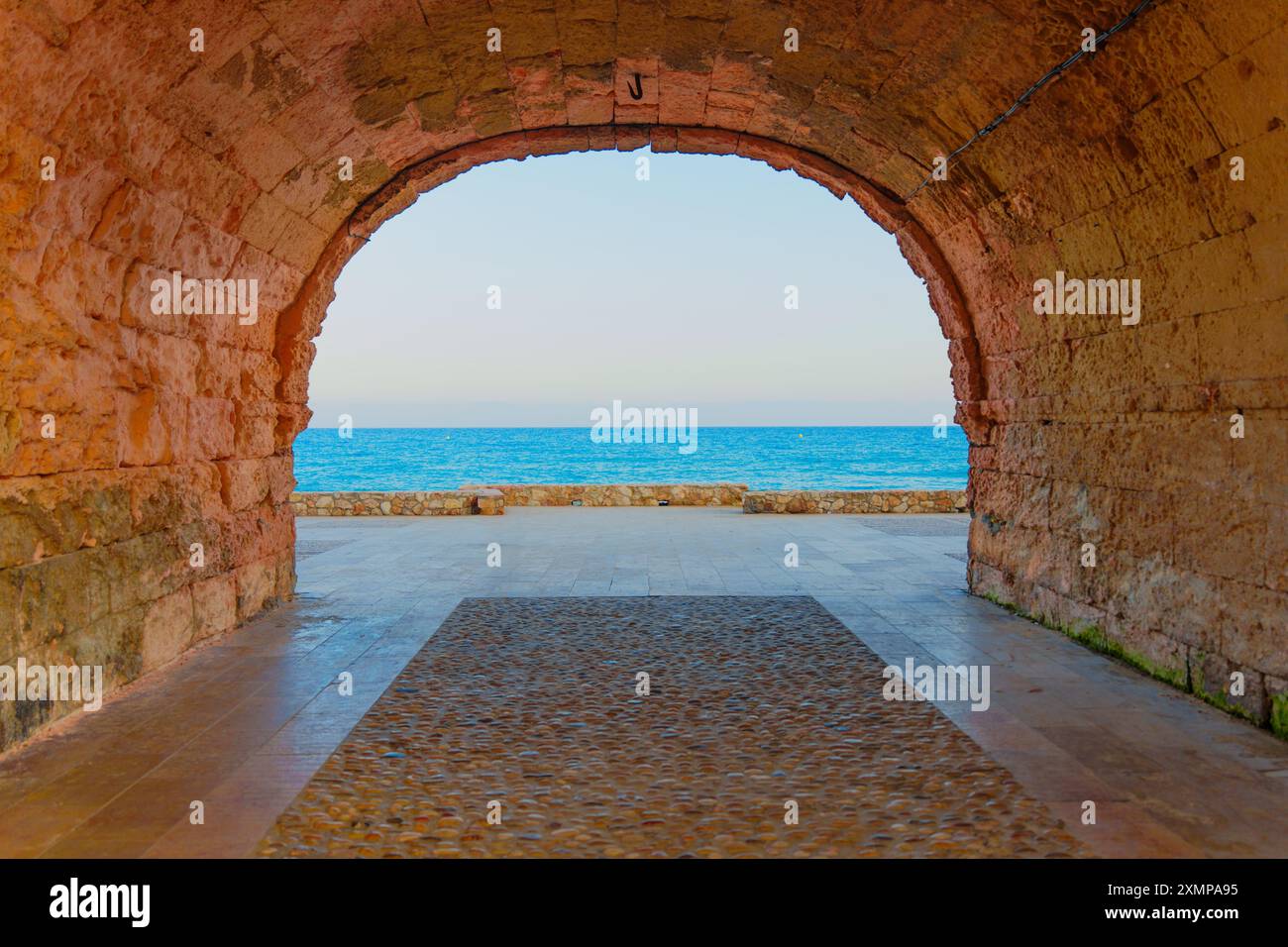 Breathtaking view of the sea seen through an ancient stone archway in ...