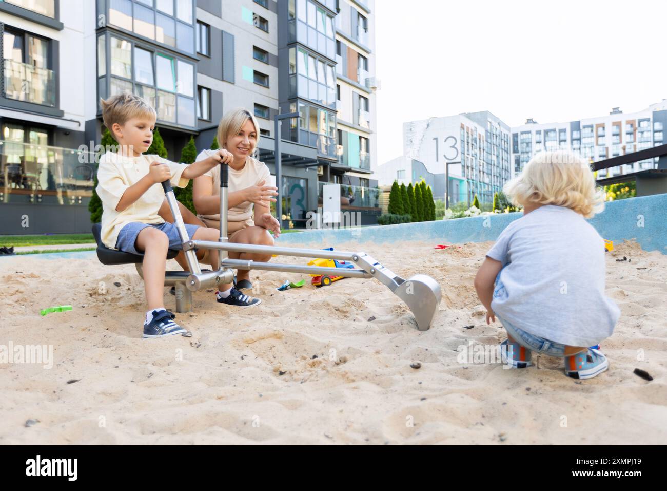 Mother Engaging With Her Two Sons While Playing in the Sand at a ...