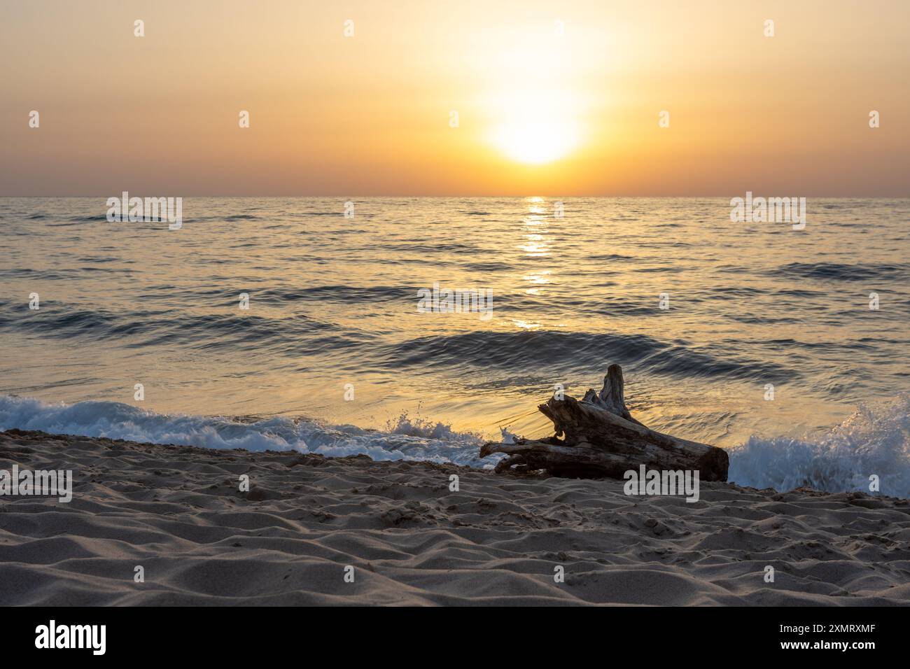 Sunset over Calm Ocean Waves on Sandy Beach Stock Photo - Alamy