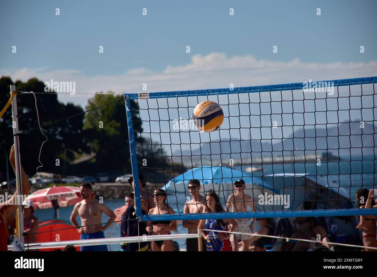 An action-packed moment from the 3x3 Ladeira Beach Volleyball Tournament in Baiona captures a volleyball soaring through the air. The dynamic scene hi Stock Photo