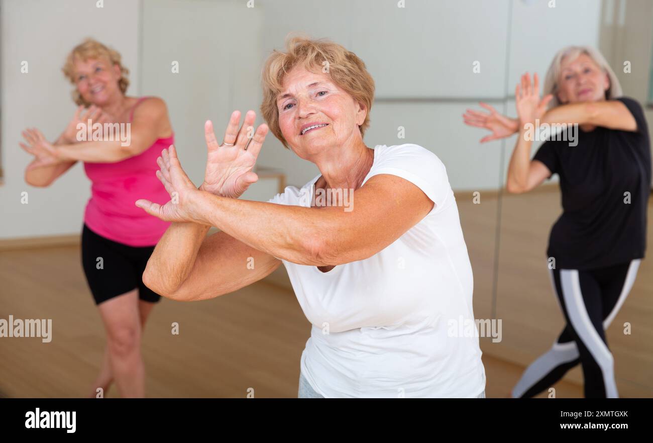 Energetic elderly woman practicing vigorous dance movements Stock Photo
