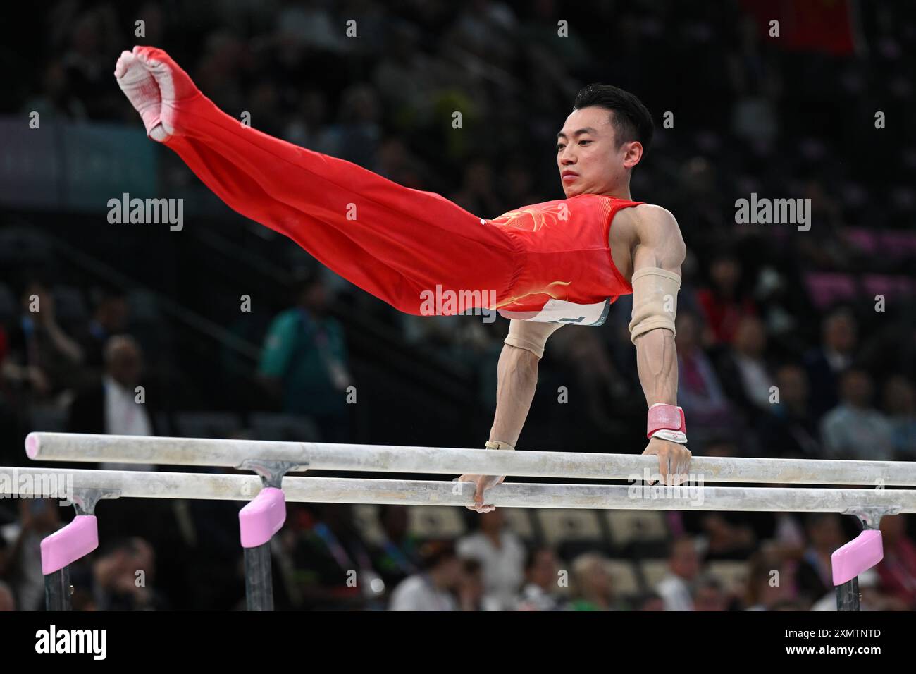 Paris, France. 29th July, 2024. Olympics, Paris 2024, gymnastics, all-around, team, men, final, Zou Jingyuan from China performs on parallel bars. Credit: Marijan Murat/dpa/Alamy Live News Stock Photo