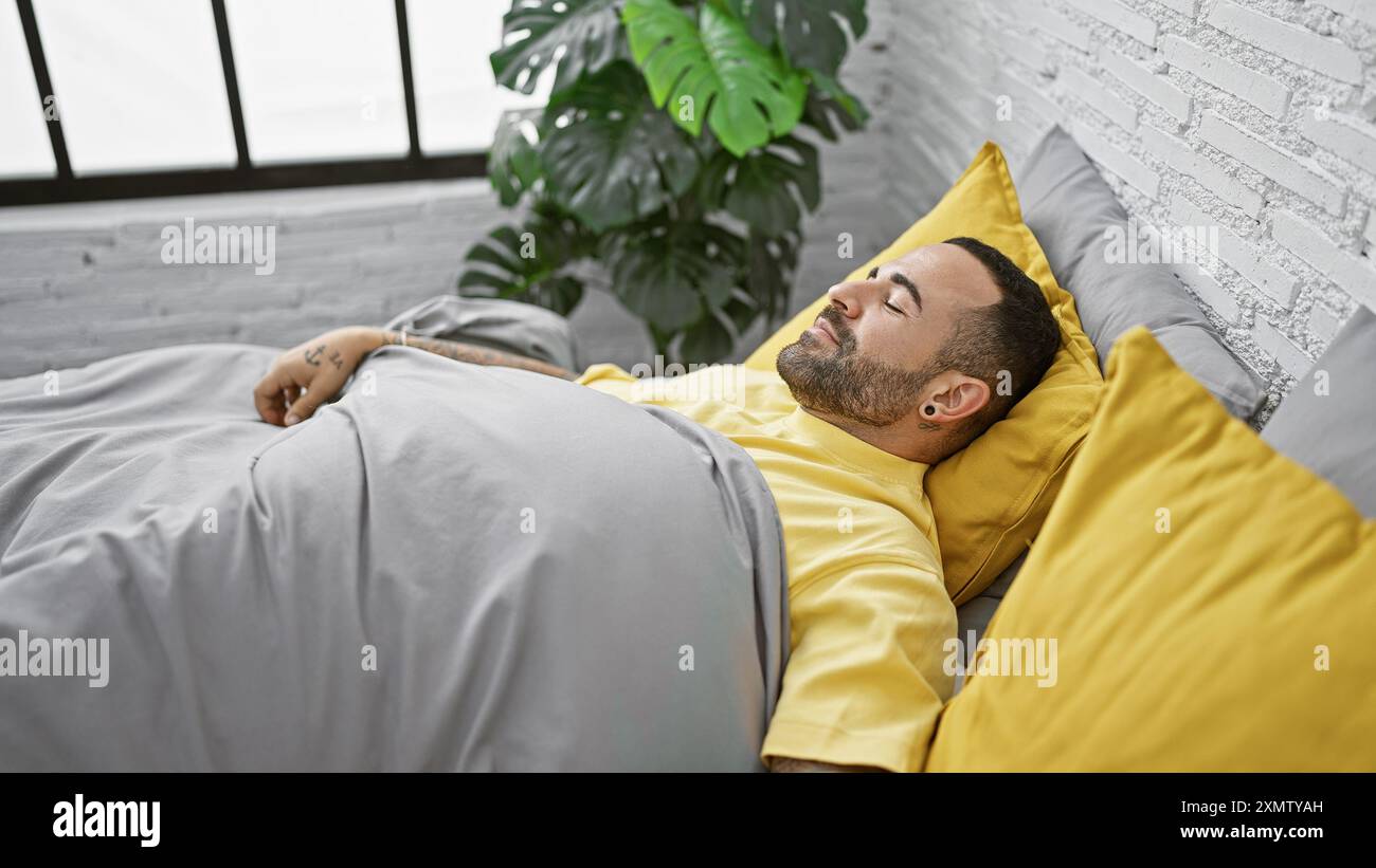 Handsome young hispanic man sleeping peacefully in a modern bedroom Stock Photo