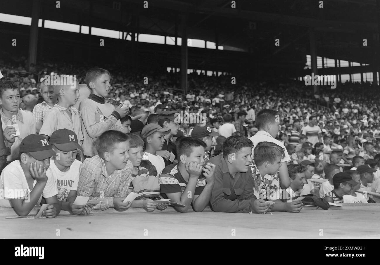 A crowd of boys hangout above the Milwaukee Braves dugout looking for autographs at County Stadium ca. 1958. Stock Photo