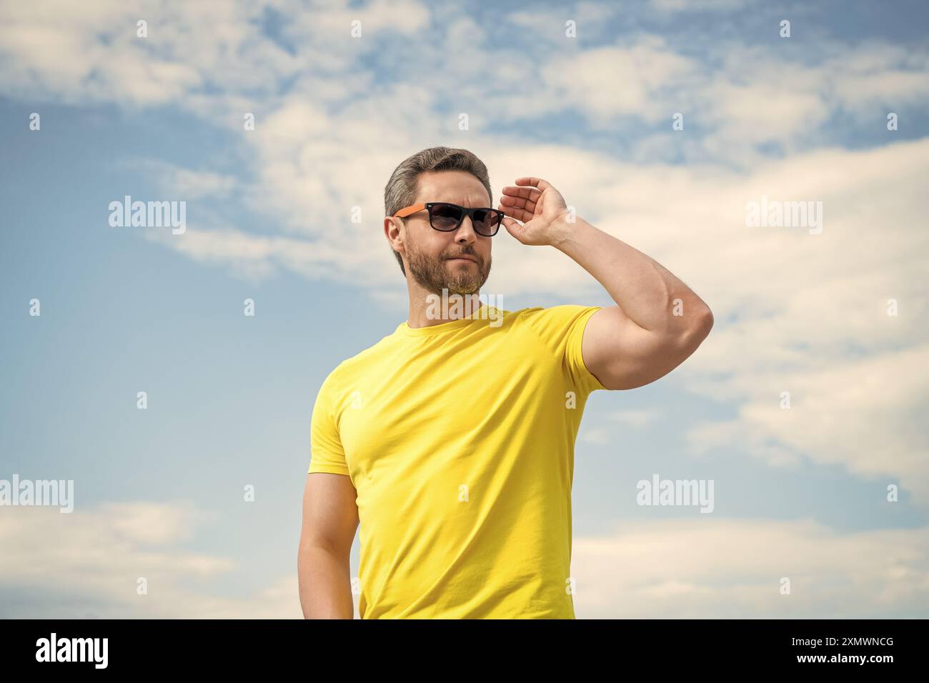 male in yellow shirt and sunglasses outdoor on sky background Stock ...