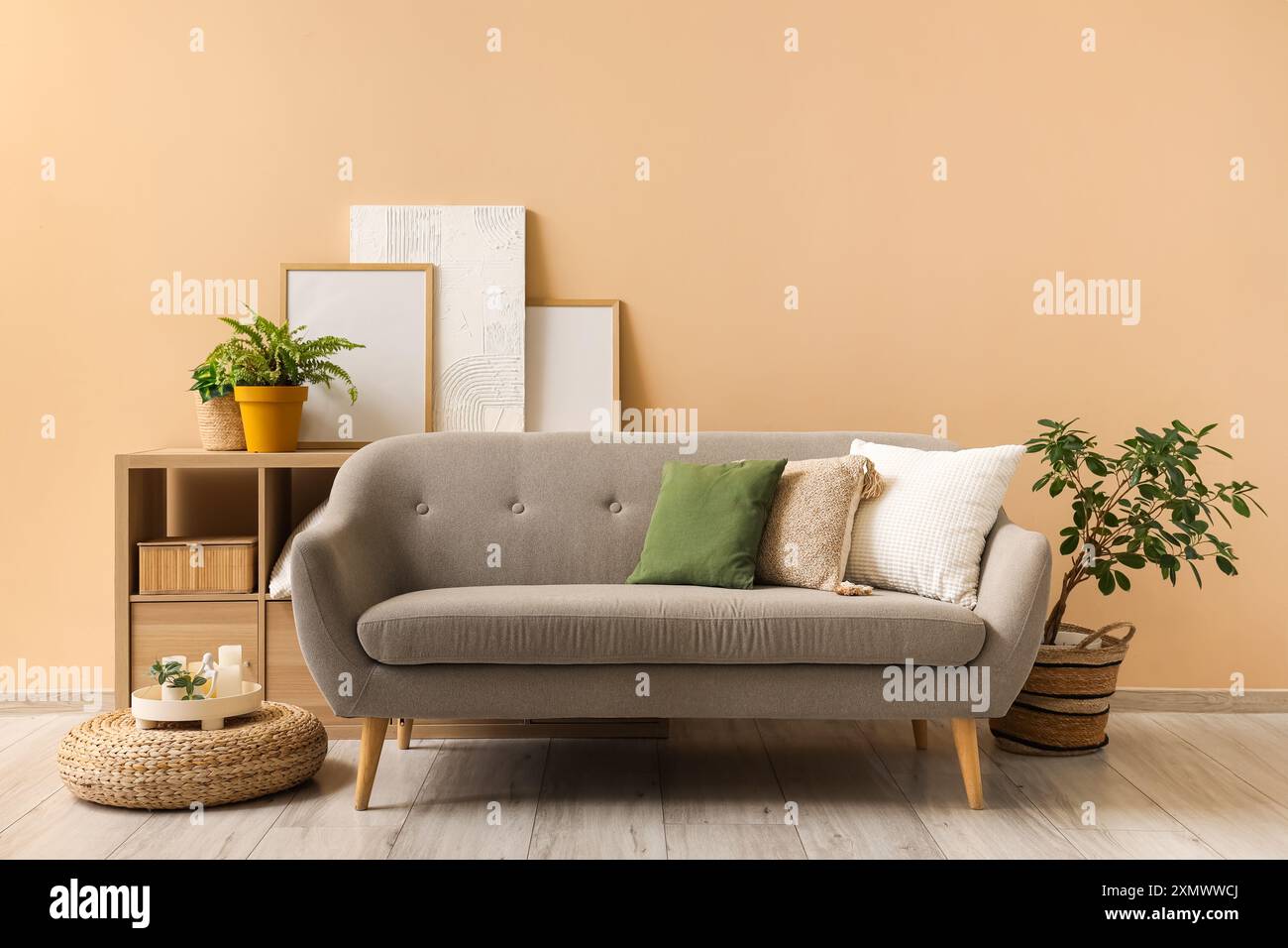 Interior of living room with grey sofa and frames Stock Photo - Alamy
