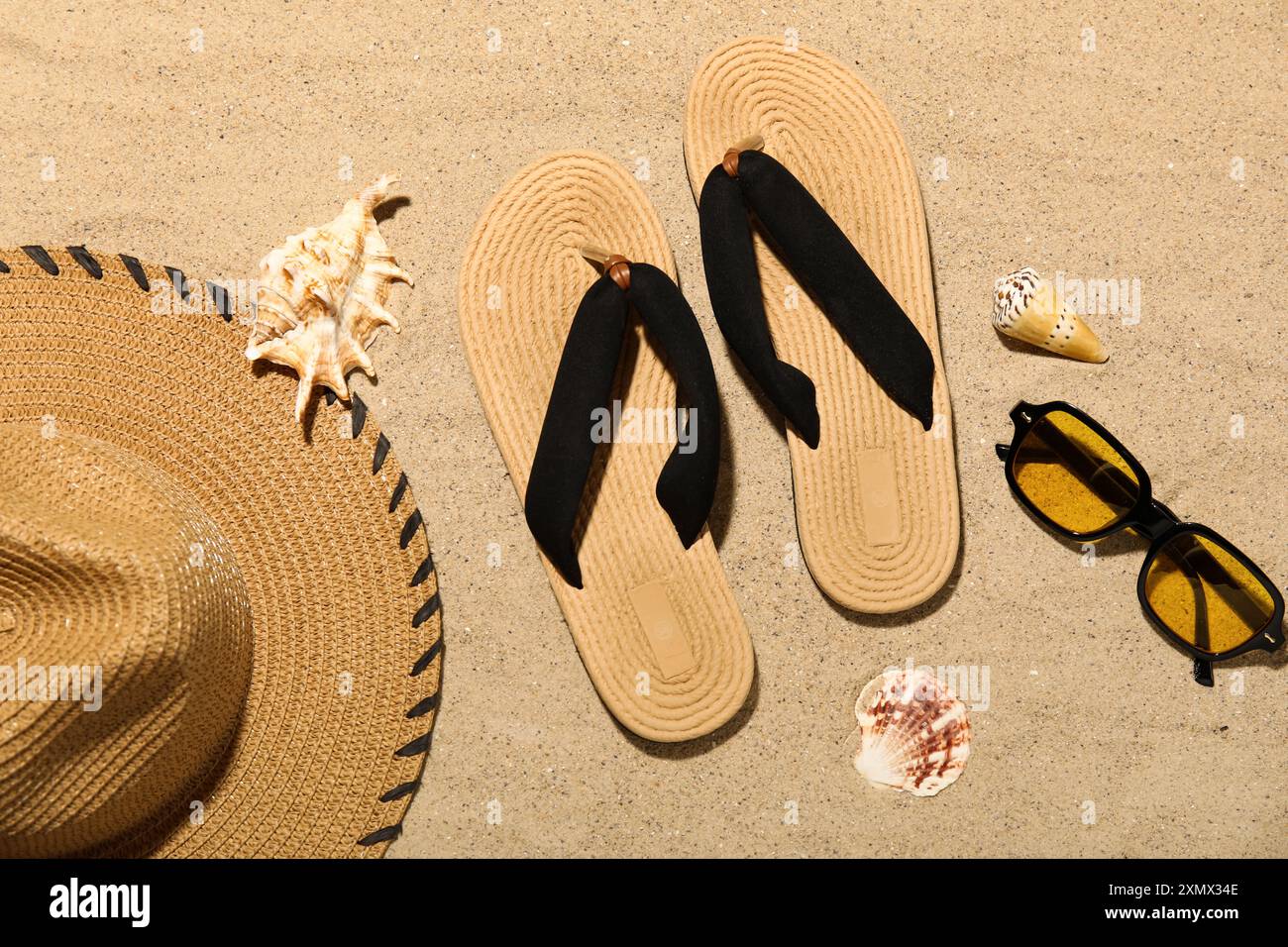 Flip flops with sunglasses, seashells and straw hat on sand Stock Photo ...