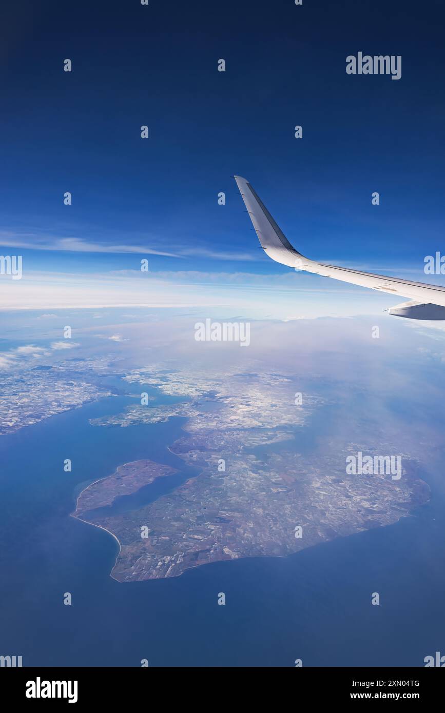 Airplane flying over color sky clouds during scenic sunset or sunrise ...