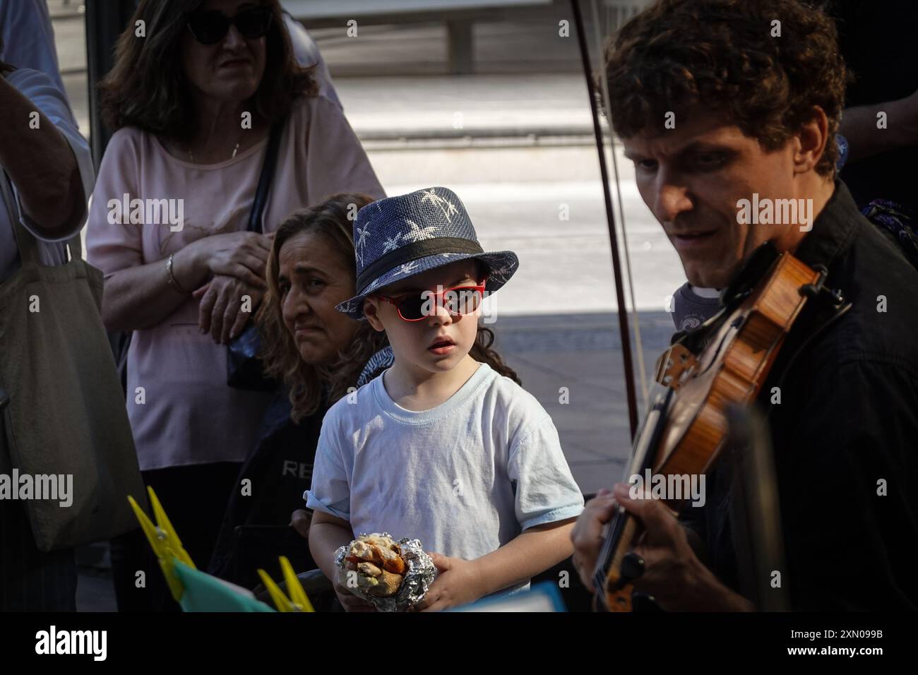 Jerusalem, Israel. 30th July, 2024. Children are captivated by musicians in an open street concert in downtown Jerusalem. Credit: Nir Alon/Alamy Live News Stock Photo