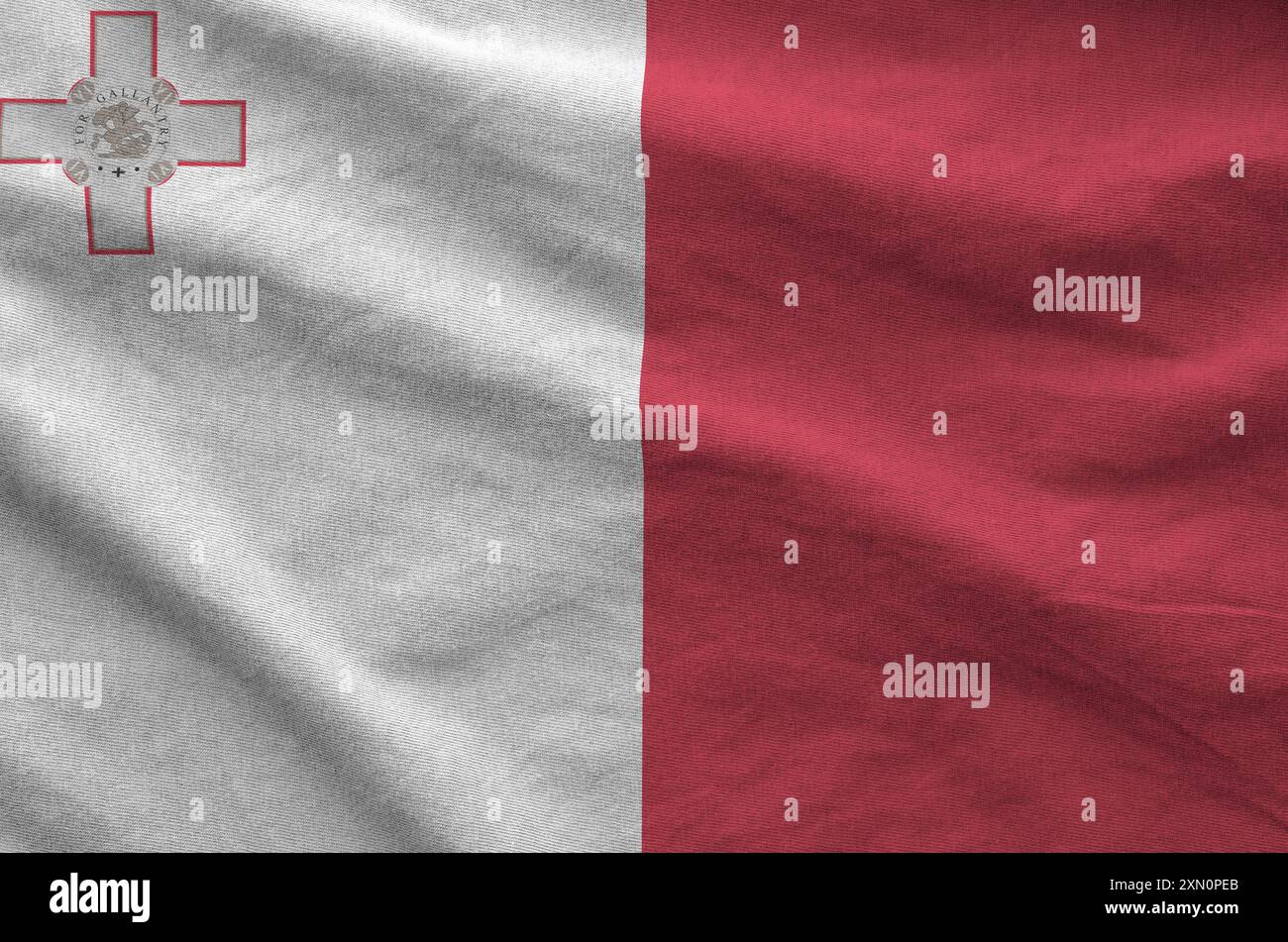 Malta flag depicted on folded wavy fabric of old cloth close up Stock Photo