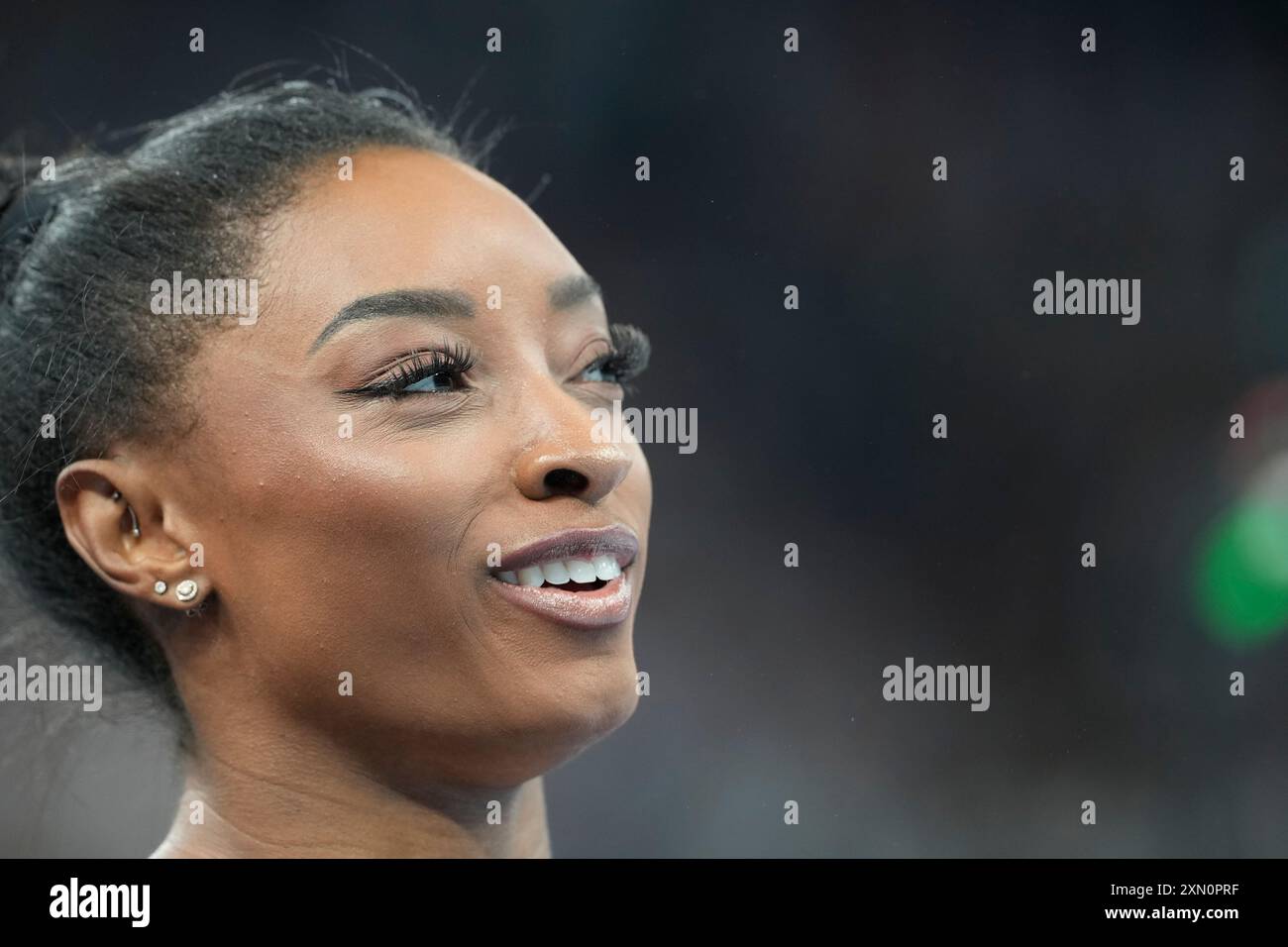 Simone Biles, of the United States, prepares to performs on the uneven ...