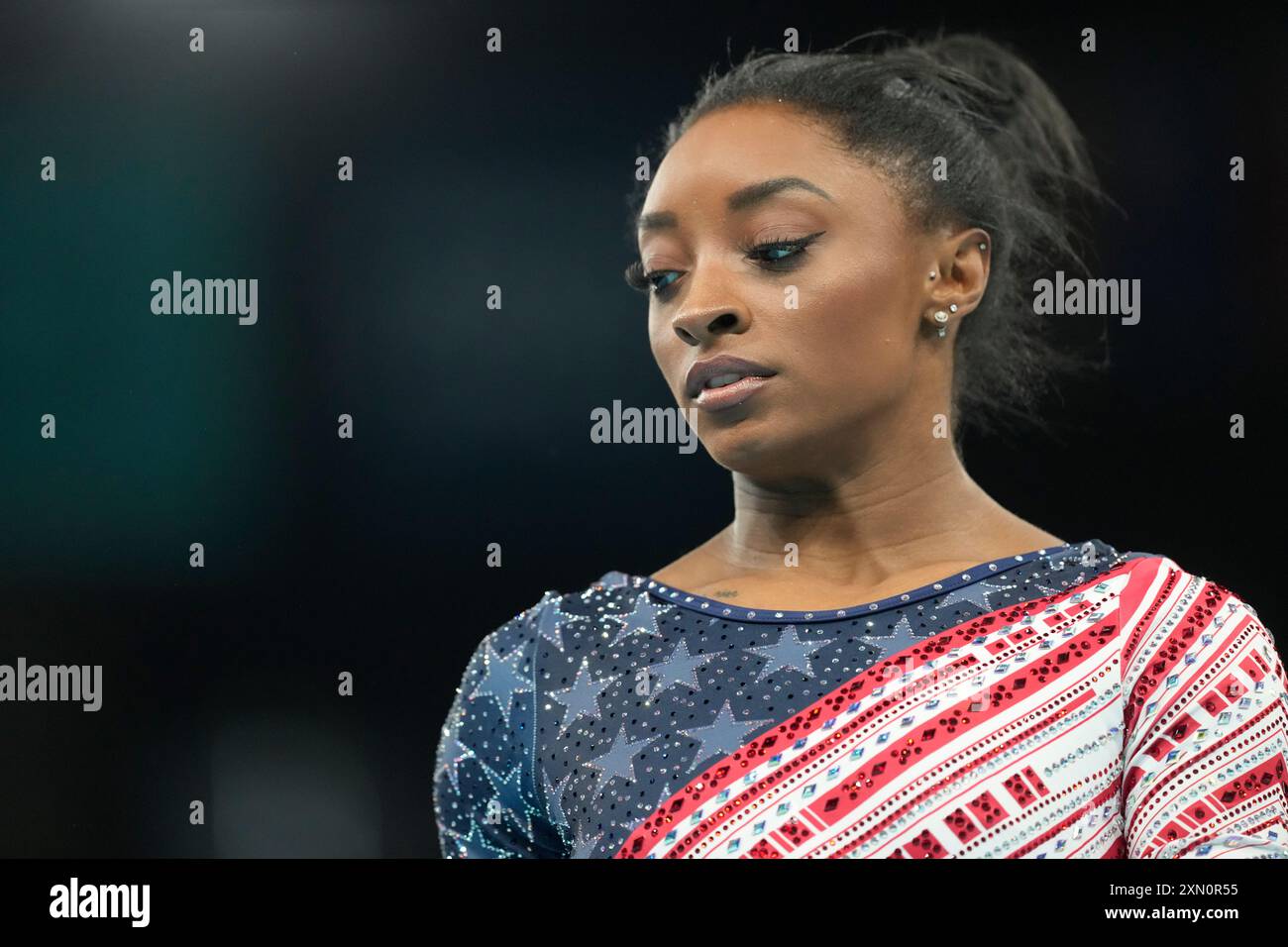 Simone Biles, of the United States, prepares to performs on the uneven ...