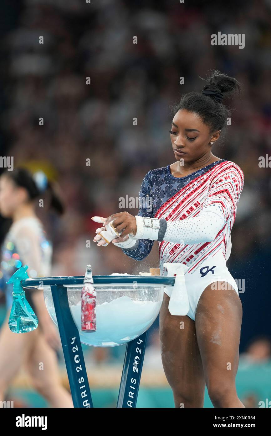 Simone Biles, of the United States, prepares to performs on the uneven ...
