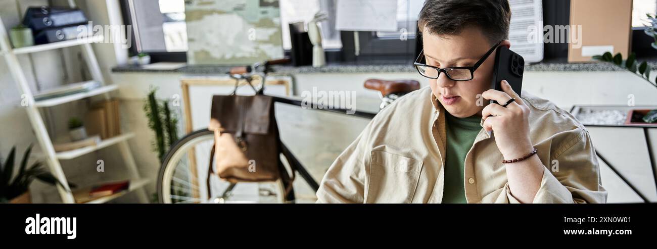 A young man with Down syndrome is talking on a cell phone. Stock Photo