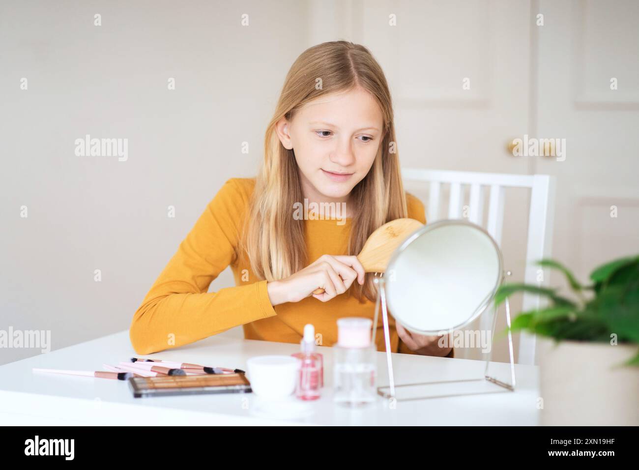 Teen Girl Brushing Her Hair in Front of a Mirror Stock Photo - Alamy