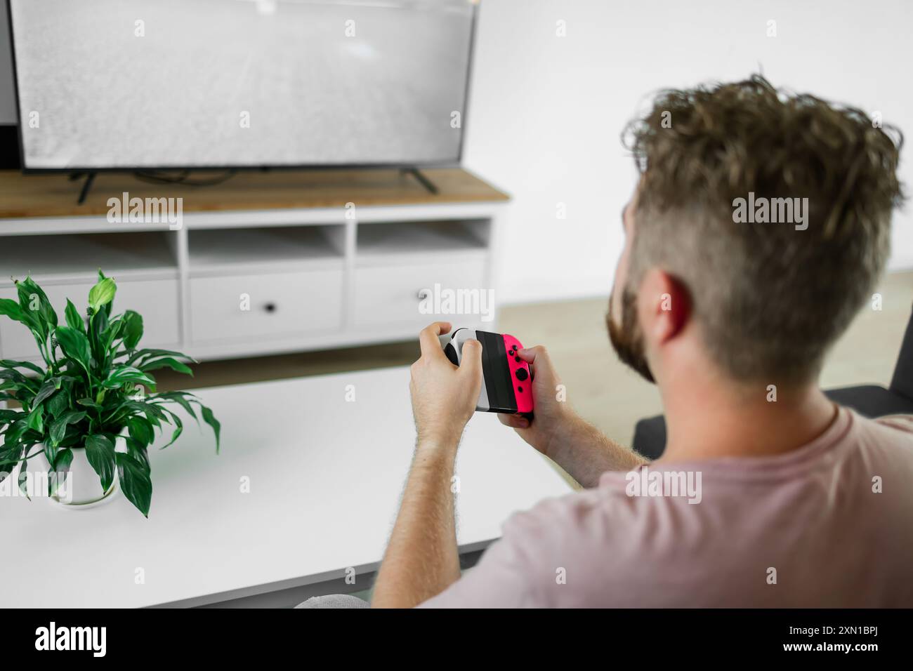 Young man spending time at home, sitting on a couch in apartment and ...