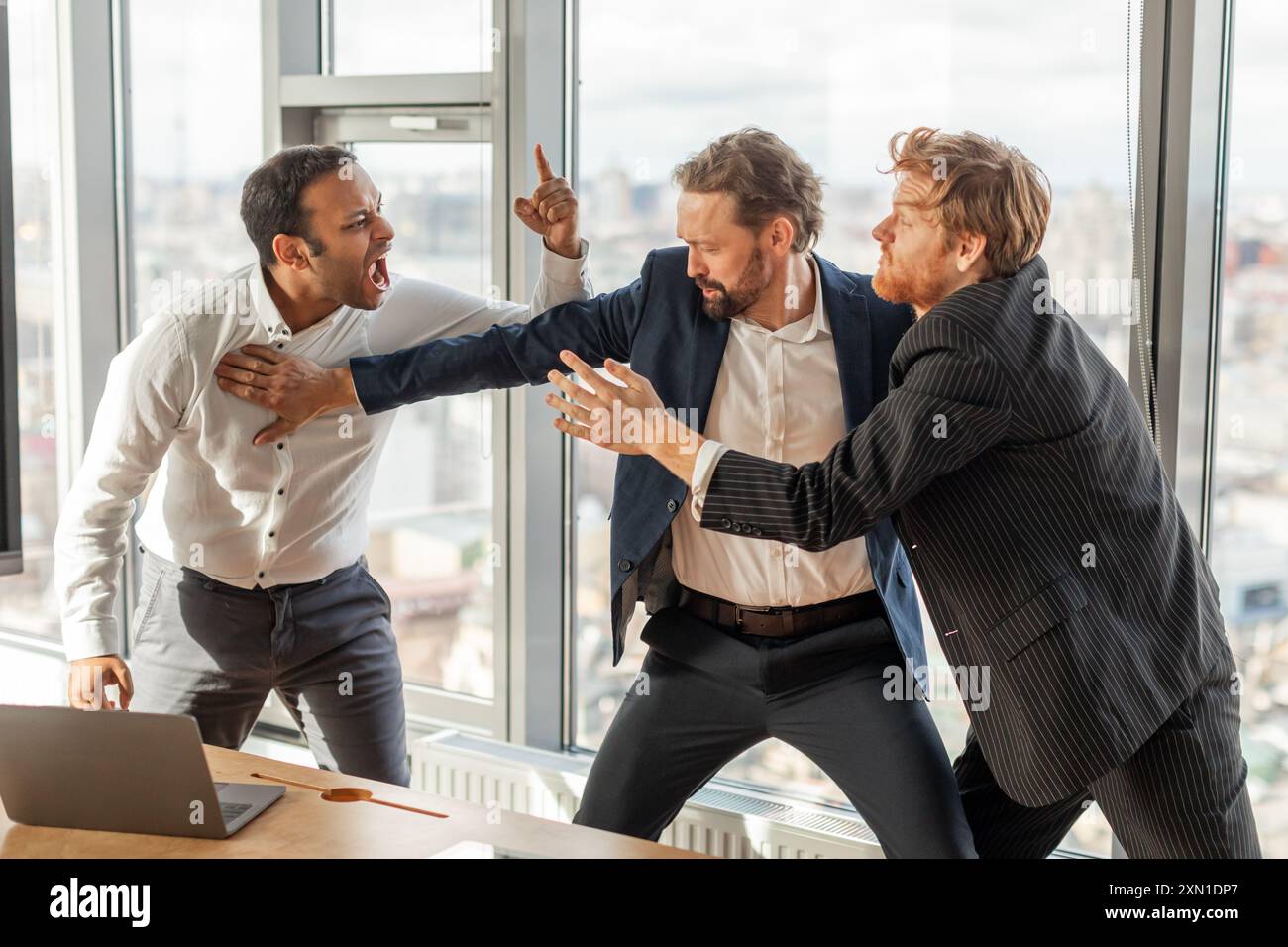 Three Businessmen Involved in Intense Argument in a Modern Office Stock Photo