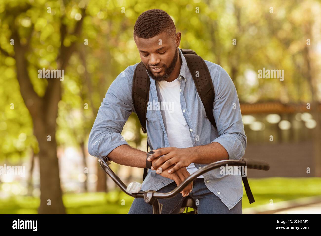 Fitness Tracker. Handsome African Man On Bike Looking At His Smartwatch ...