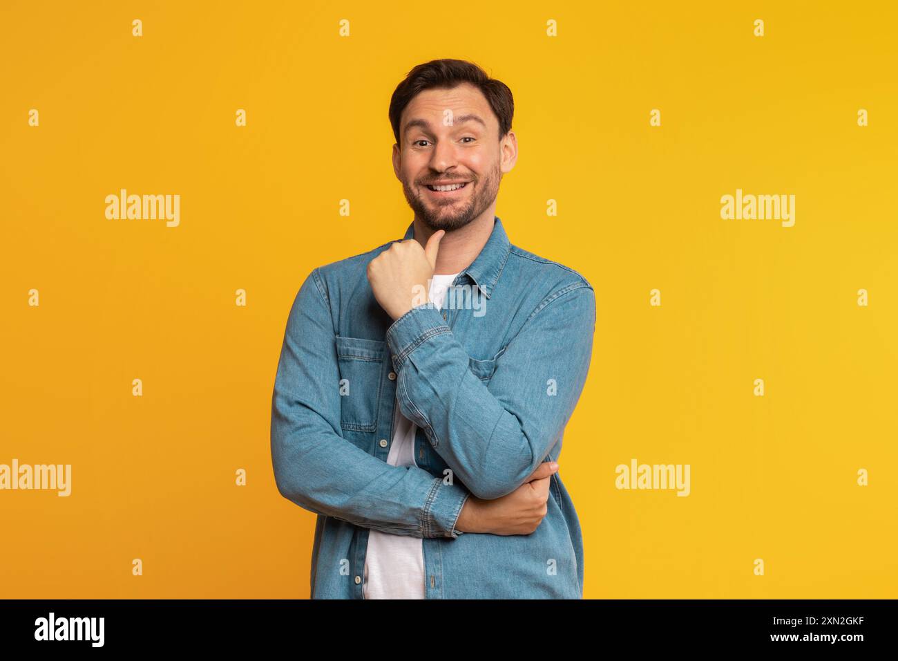 Smiling Man With Folded Arms Against A Yellow Background Stock Photo