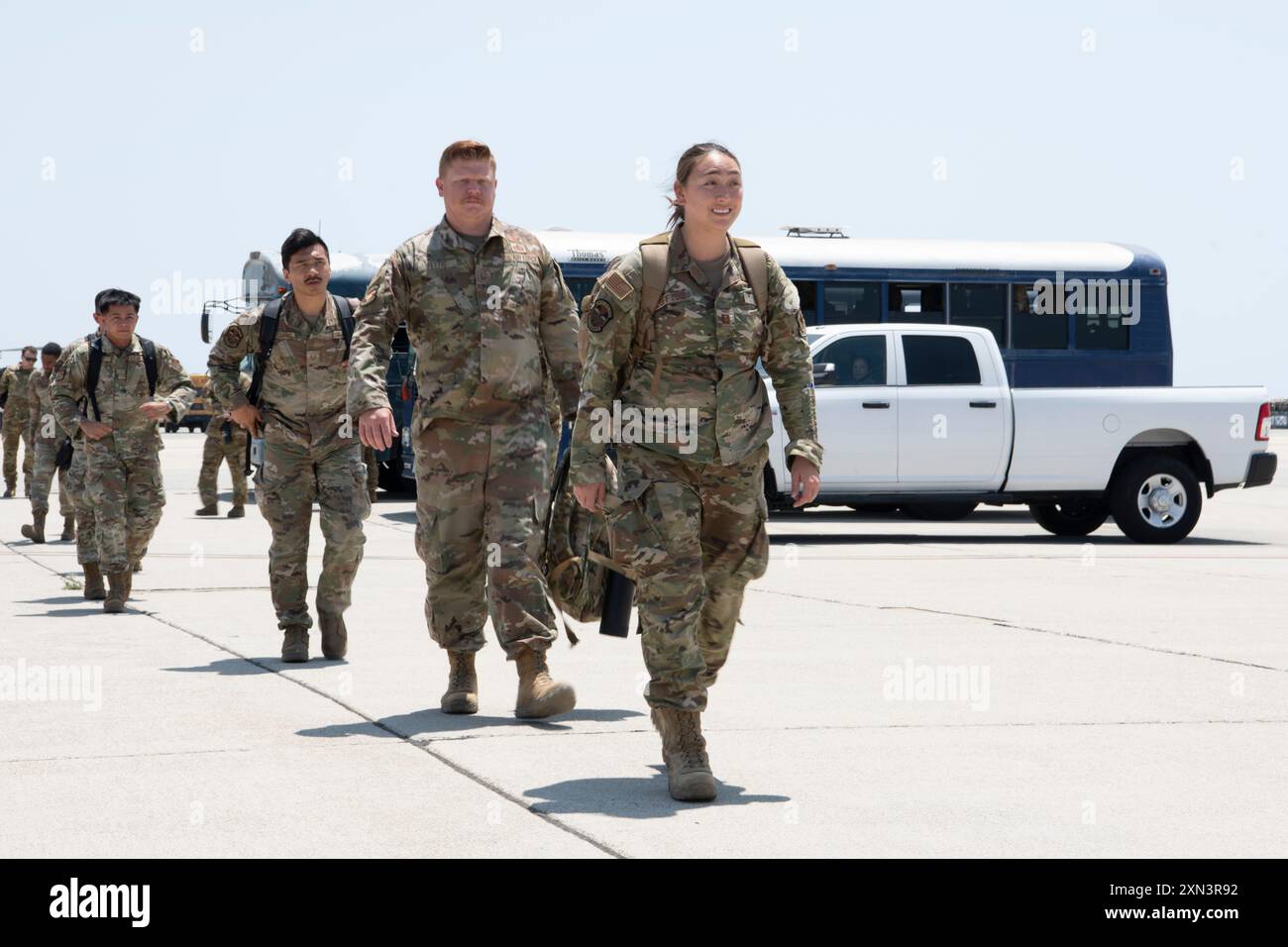 Members of the 349th Civil Engineer Squadron walk down the flight line ...