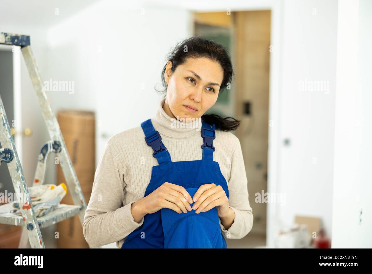 Sad woman builder standing in construction site Stock Photo