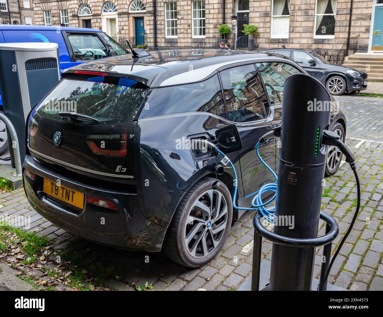 Edinburgh, Scotland, 07.17.2024: Black Mercedes electric car recharging its batteries on a charging point in a cobbled street in Edinburgh Stock Photo