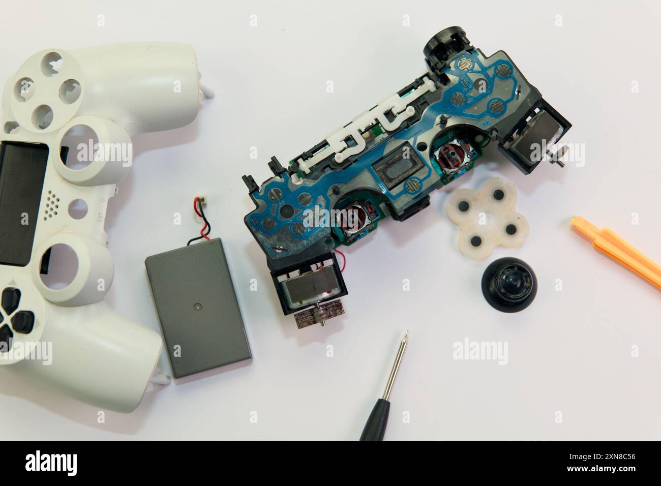 A disassembled gamepad awaits repair, showcasing its intricate ...