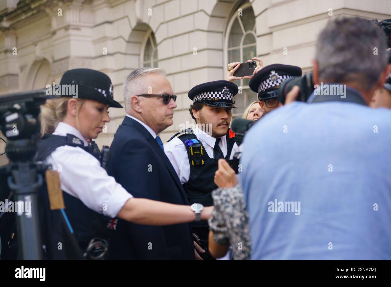 Westminster, London 31st July 2024. Huw Edwards, ex-BBC news anchor, surrounded by police and security, arrives at Westminster Magistrates court for a hearing following an arrest on charges of making indecent images of children. He will be sentenced in September.  Bridget Catterall AlamyLiveNews Stock Photo