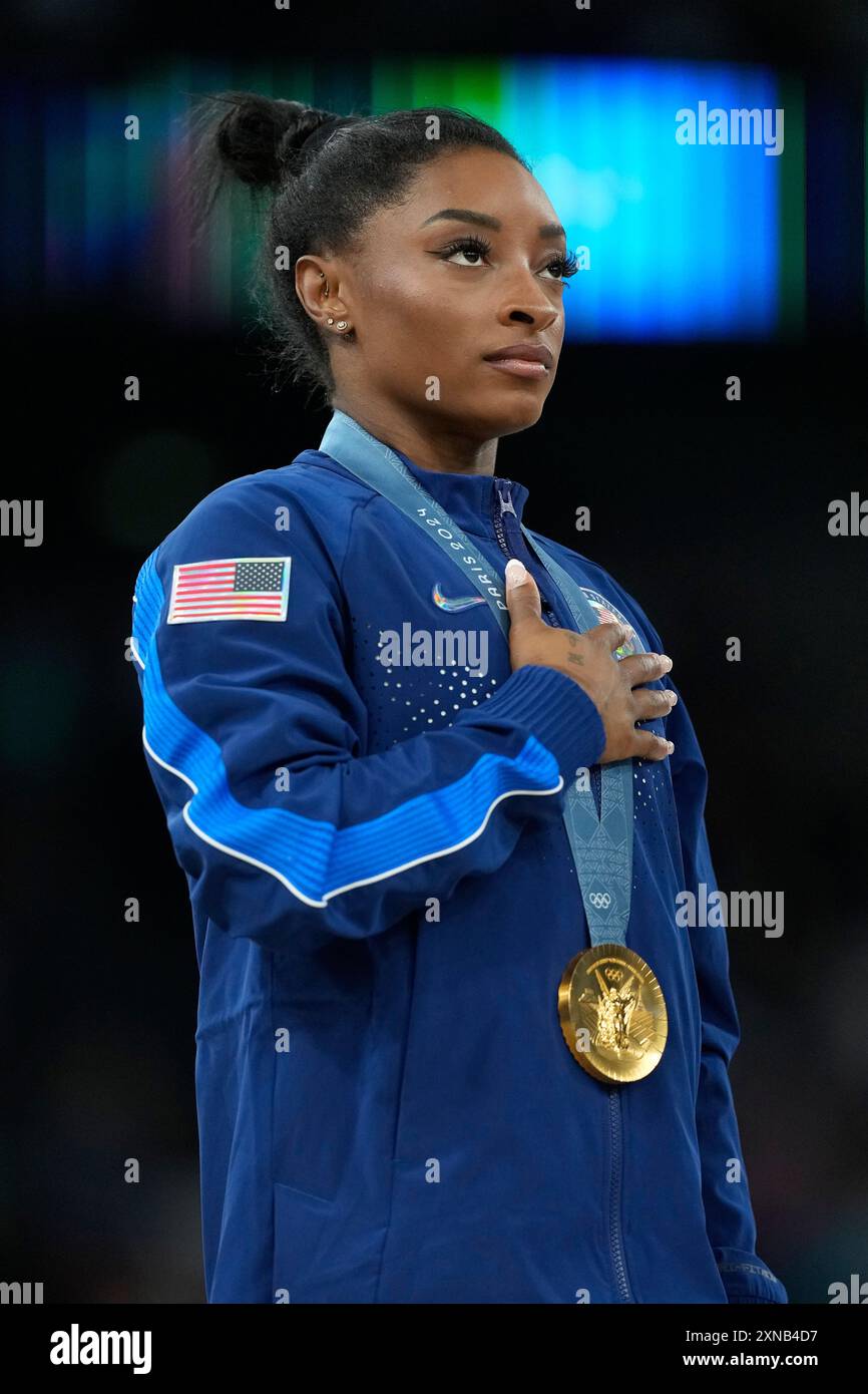 Simone Biles, of the United States stands for the national anthem after ...