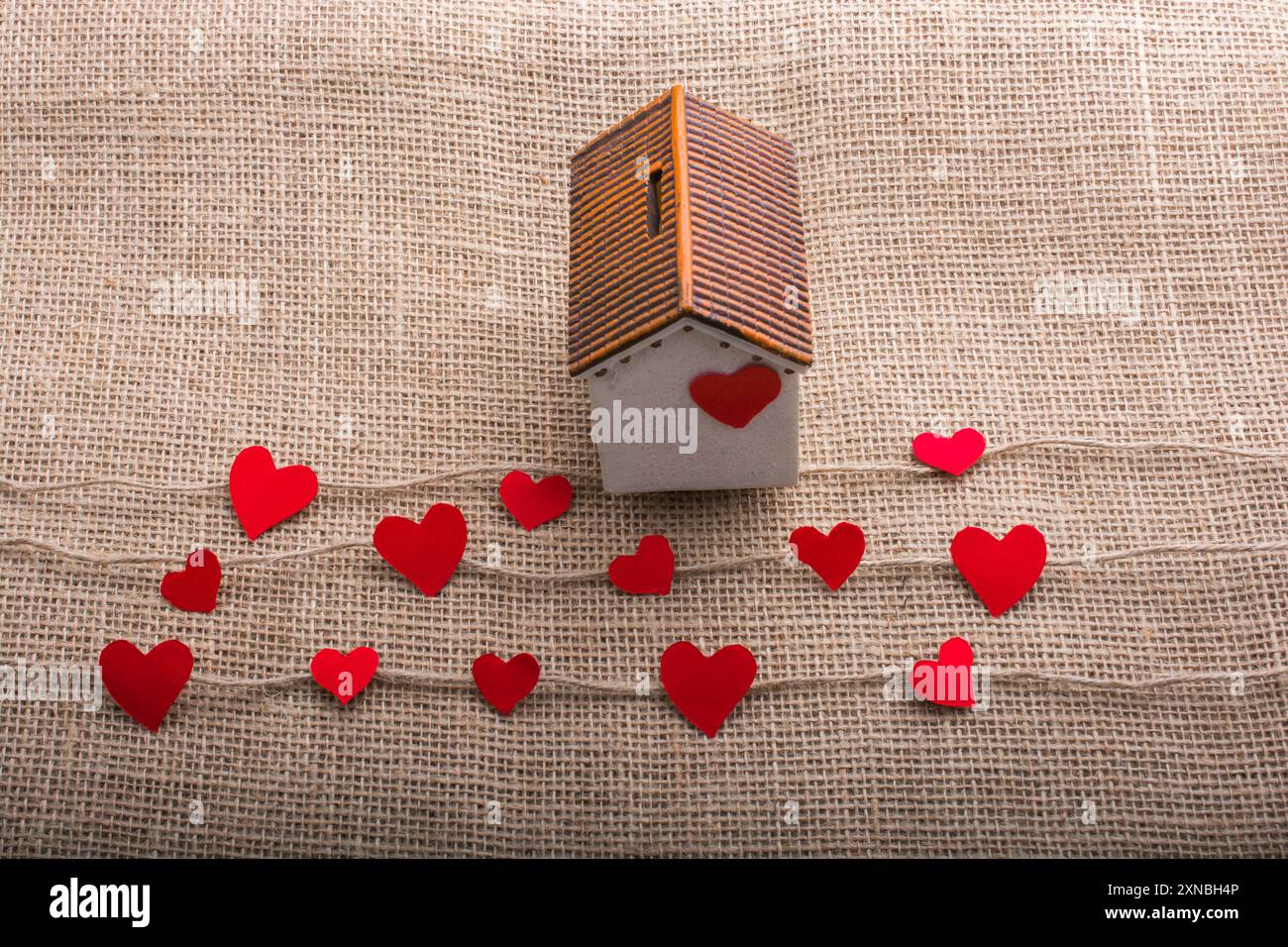 Heart shaped icons and paper house on linen threads Stock Photo - Alamy