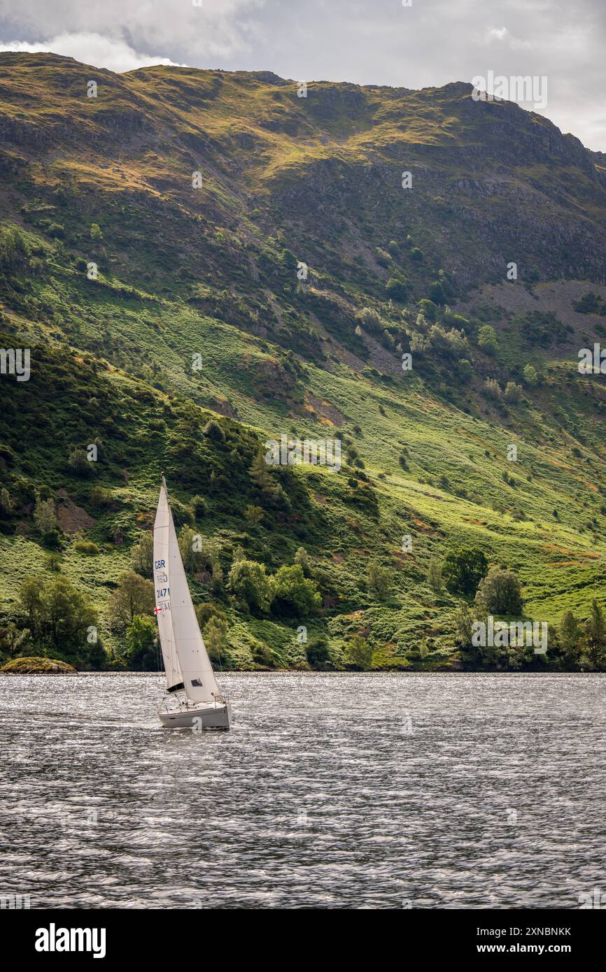 Yacht on Ullswater lake in the lake district with Birk Fell behind. Stock Photo