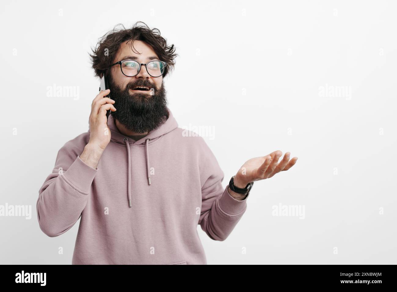 Bearded man talking on the phone with a perplexed expression Stock Photo