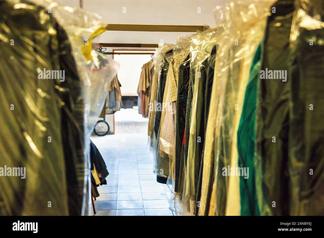 racks with clothes in plastic bags, industrial cleaning Stock Photo - Alamy