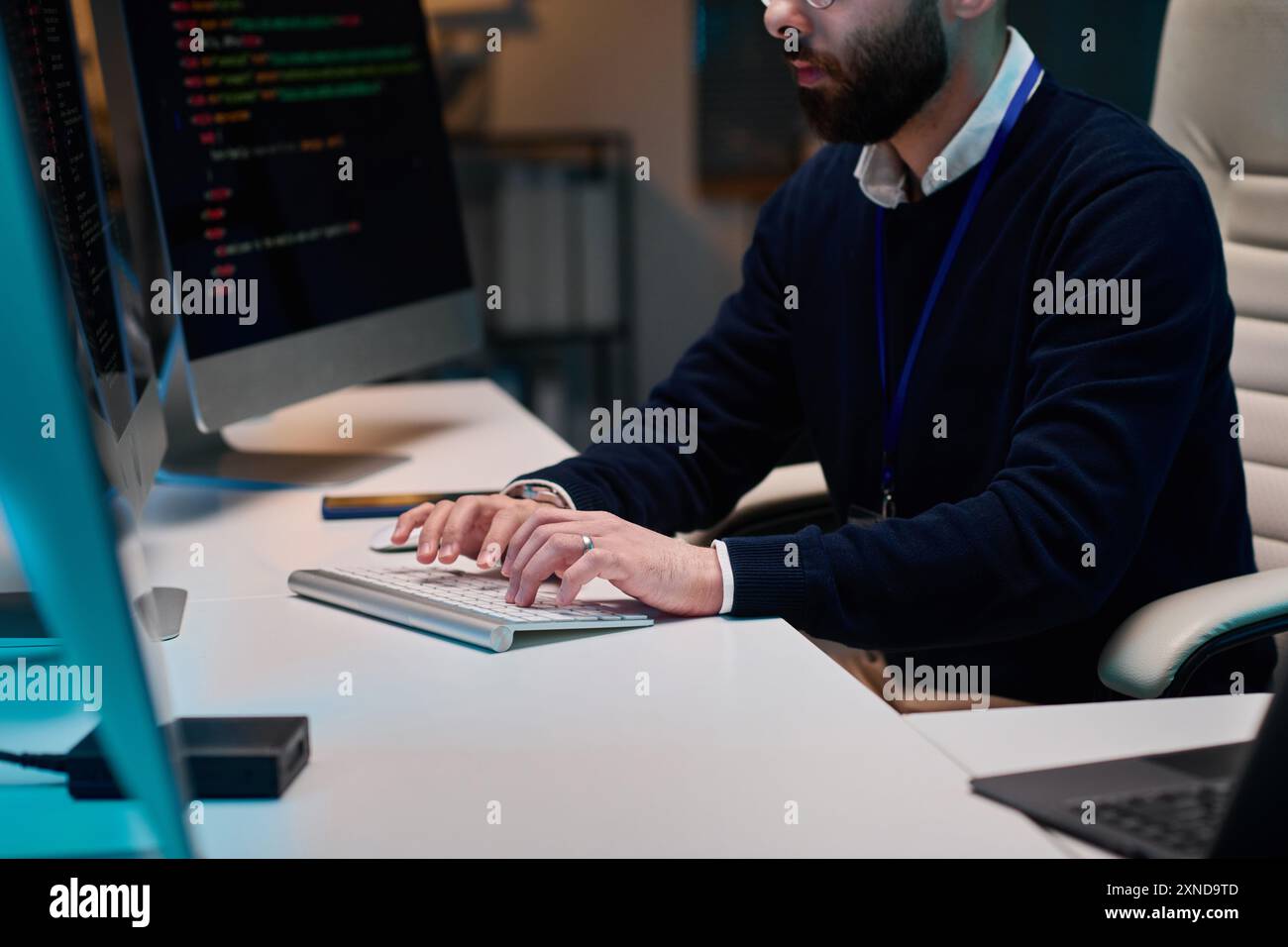 Cropped shot of bearded software developer writing code and typing on computer keyboard in office copy space Stock Photo