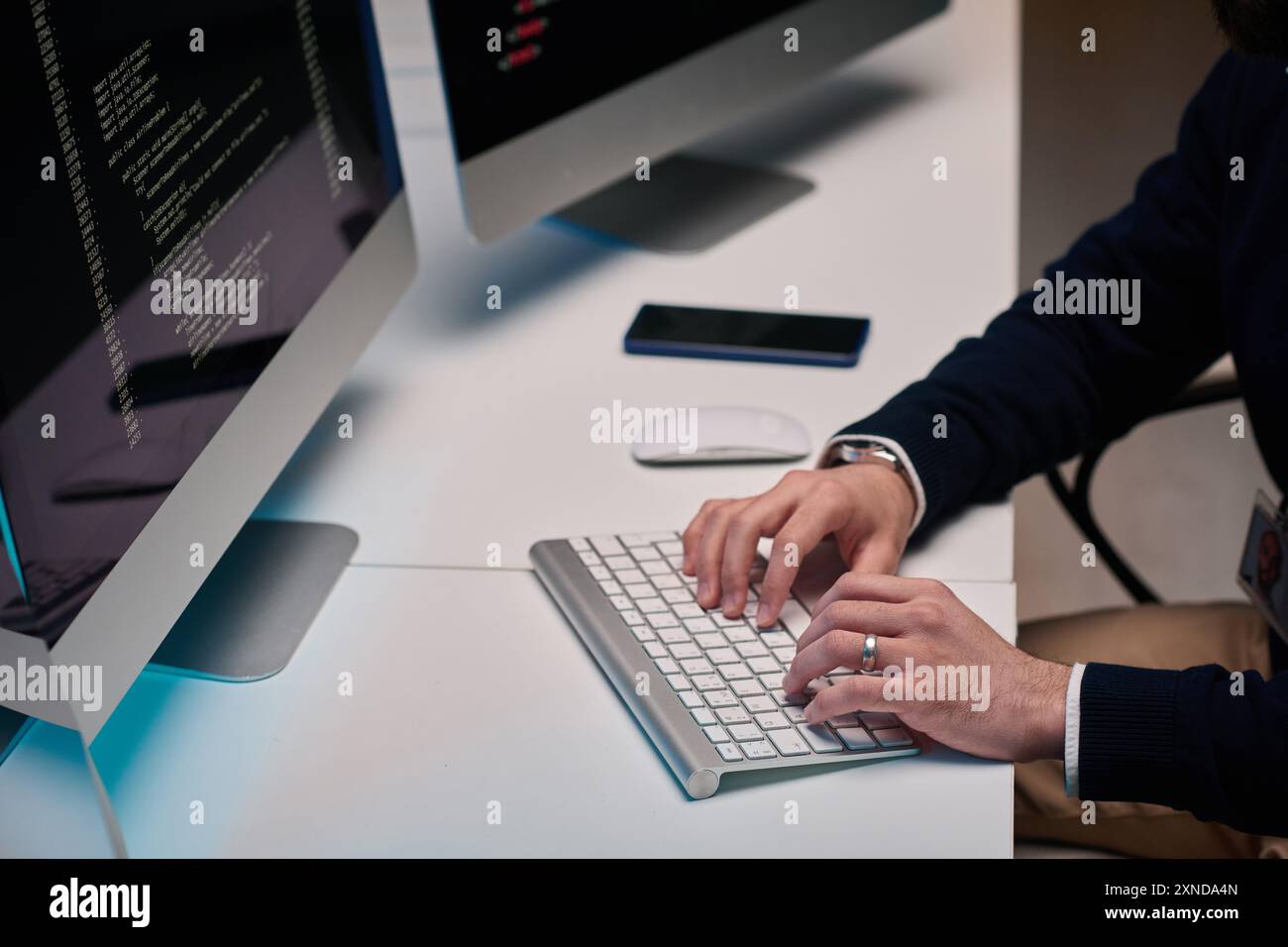 Minimal high angle closeup of unrecognizable man typing on keyboard and using computer while working at desk copy space Stock Photo