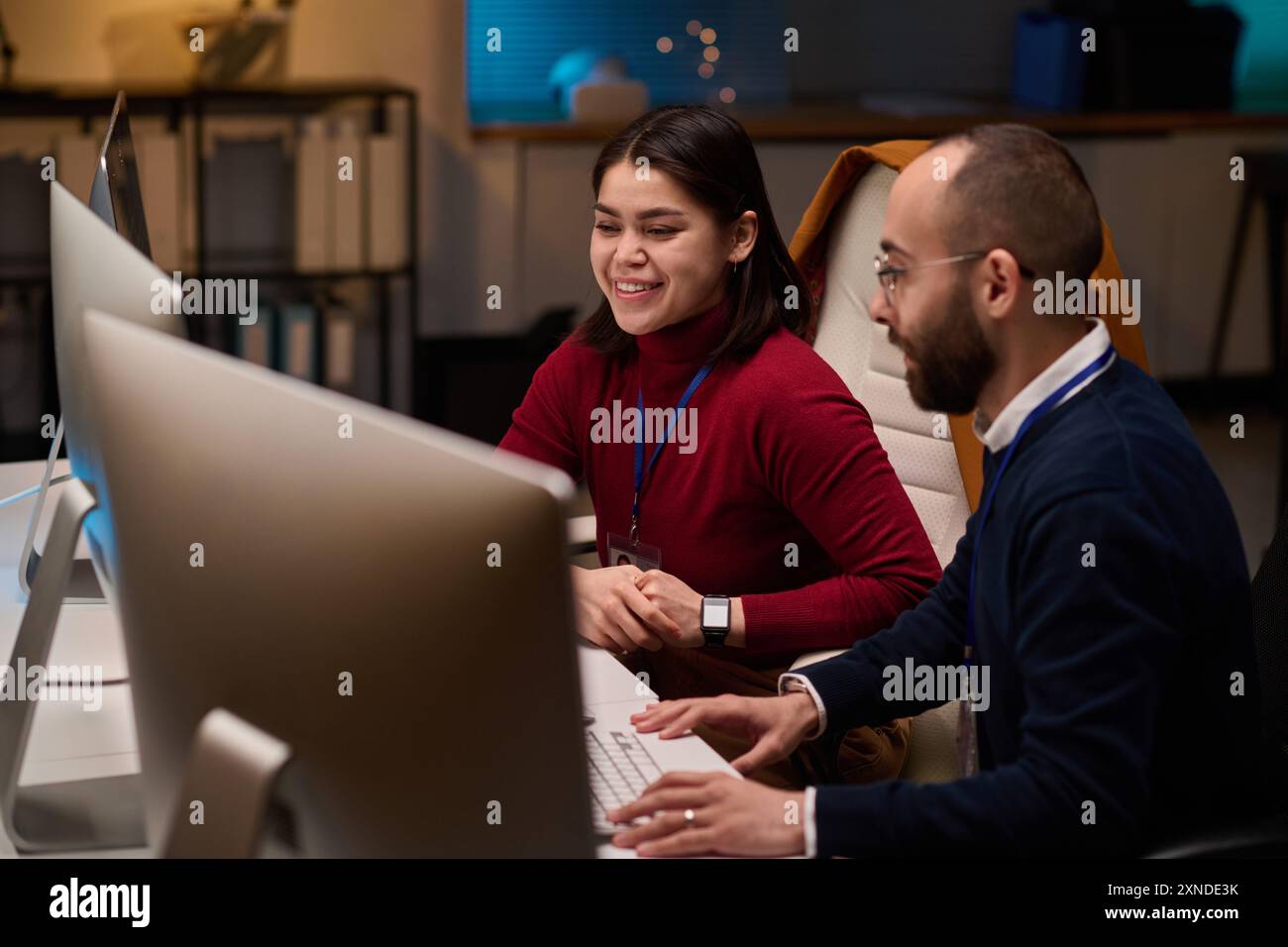 High angle portrait of two software developers collaborating on project and looking at computer screens with smile Stock Photo