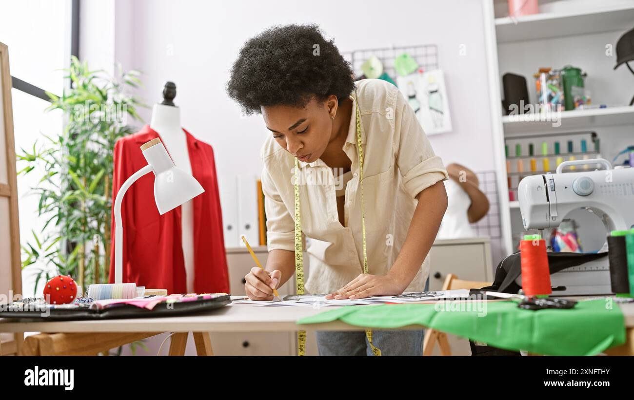 African american woman fashion designer drawing in modern atelier with ...