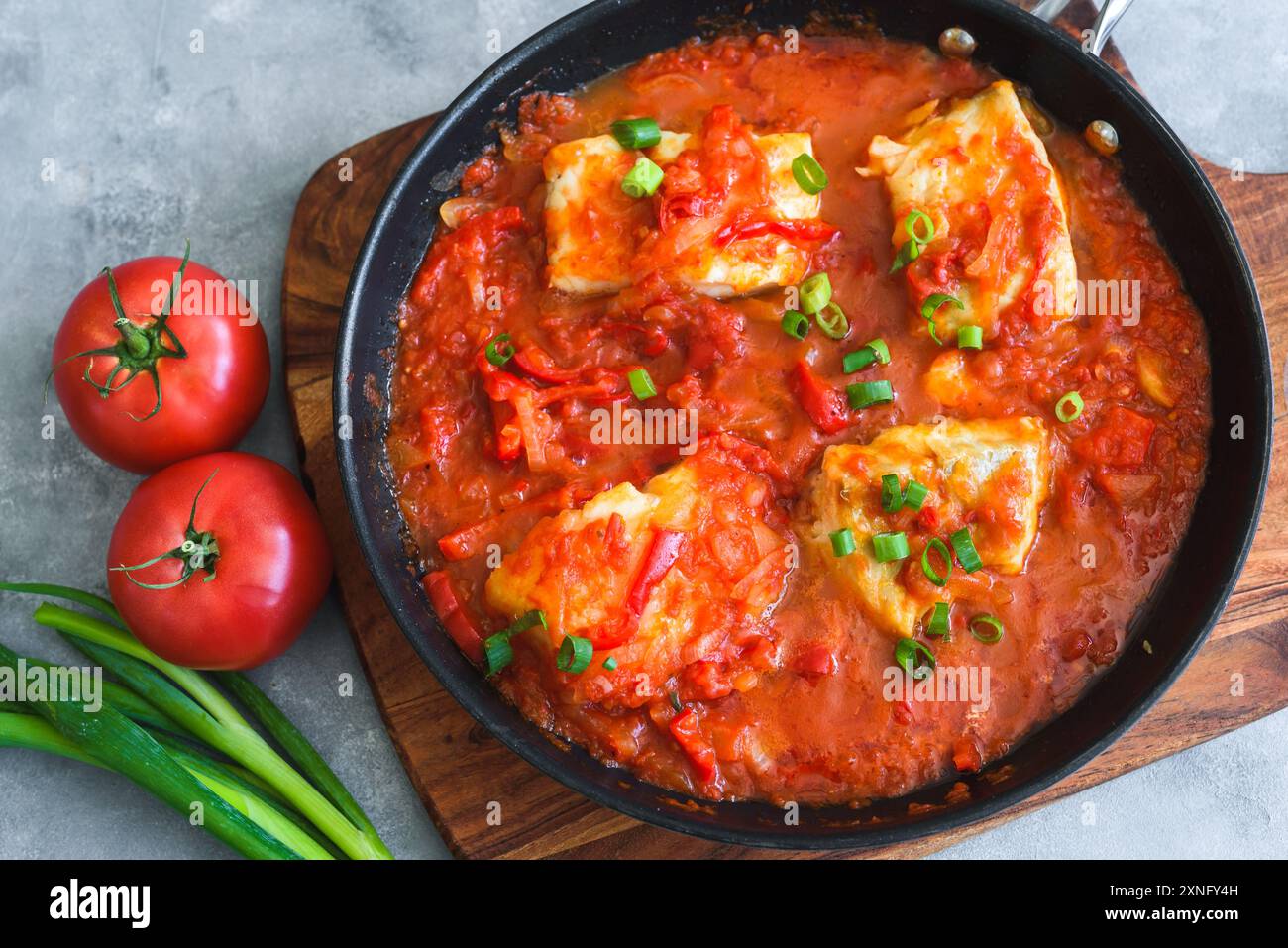 Baked cod fish in tomato and pepper sauce Stock Photo