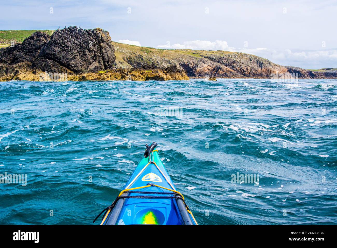 A sea kayak in the tide races of Rhoscolyn Beacon off Anglesey, North ...
