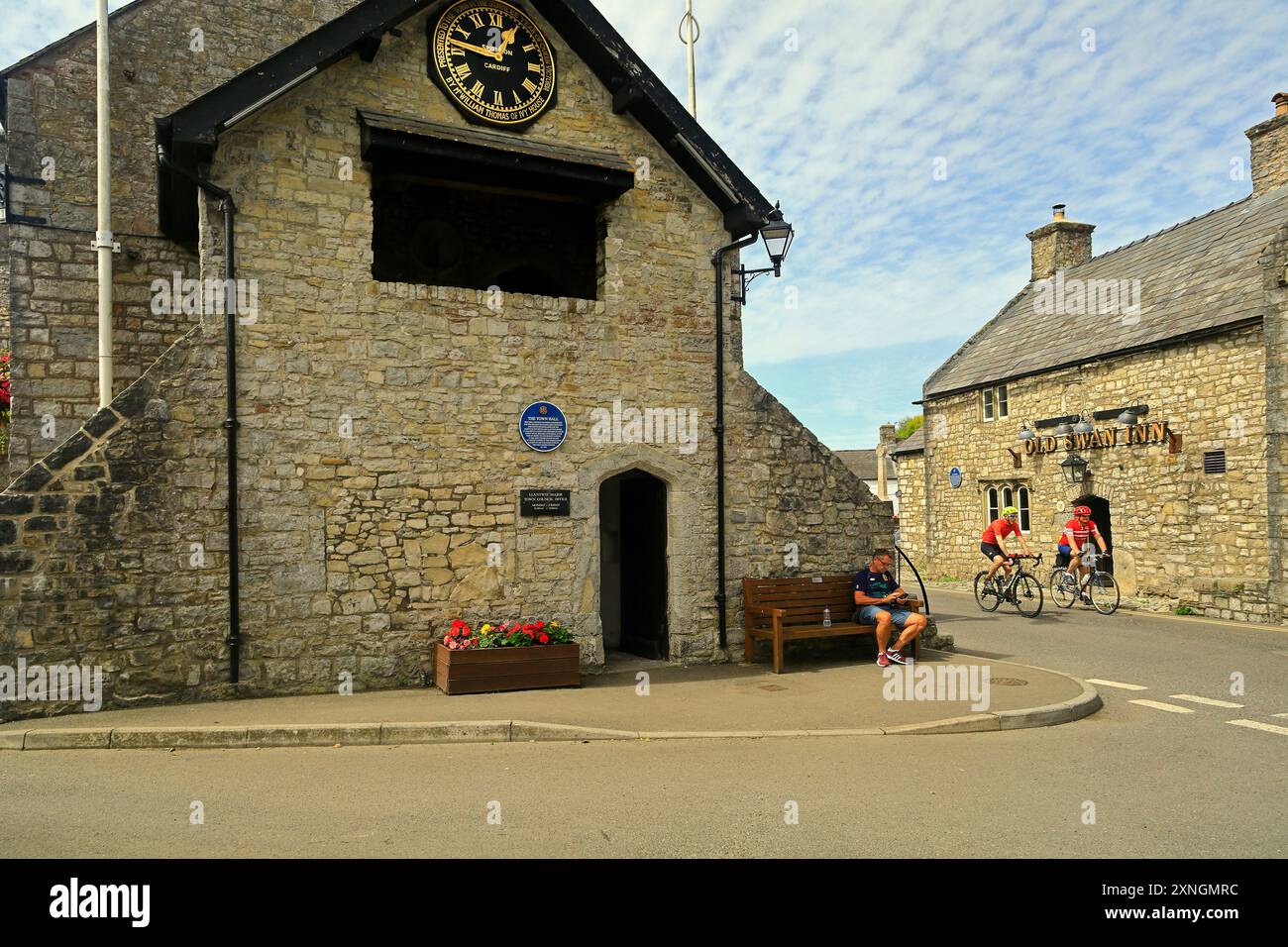The historic town Hall and clock and The Old Swan Inn with cyclists passing, Llantwit Major, Vale of Glamorgan, South Wales. Taken July 2024. Summer Stock Photo