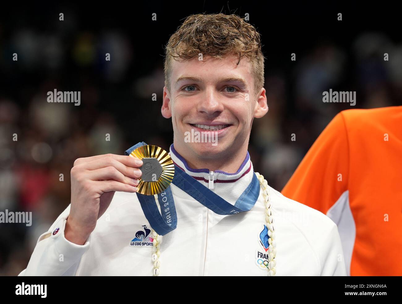 France's Leon Marchand poses with his gold medal after winning the men