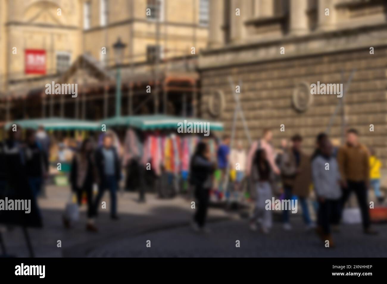 Blurry image of a crowd of people walking on a cobblestone street in ...