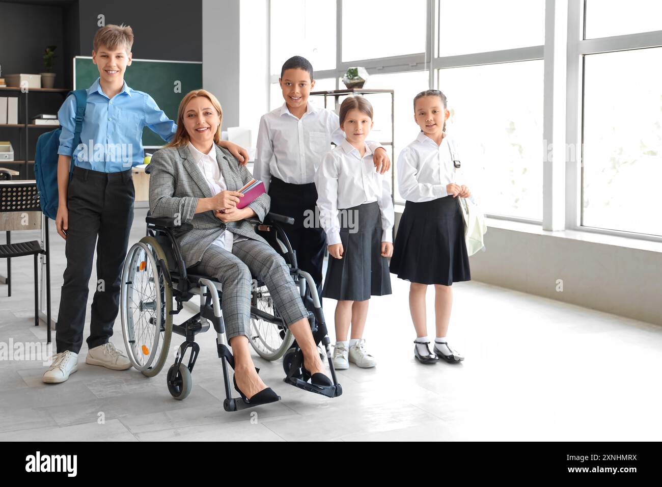 Mature teacher in wheelchair with little pupils at school Stock Photo ...