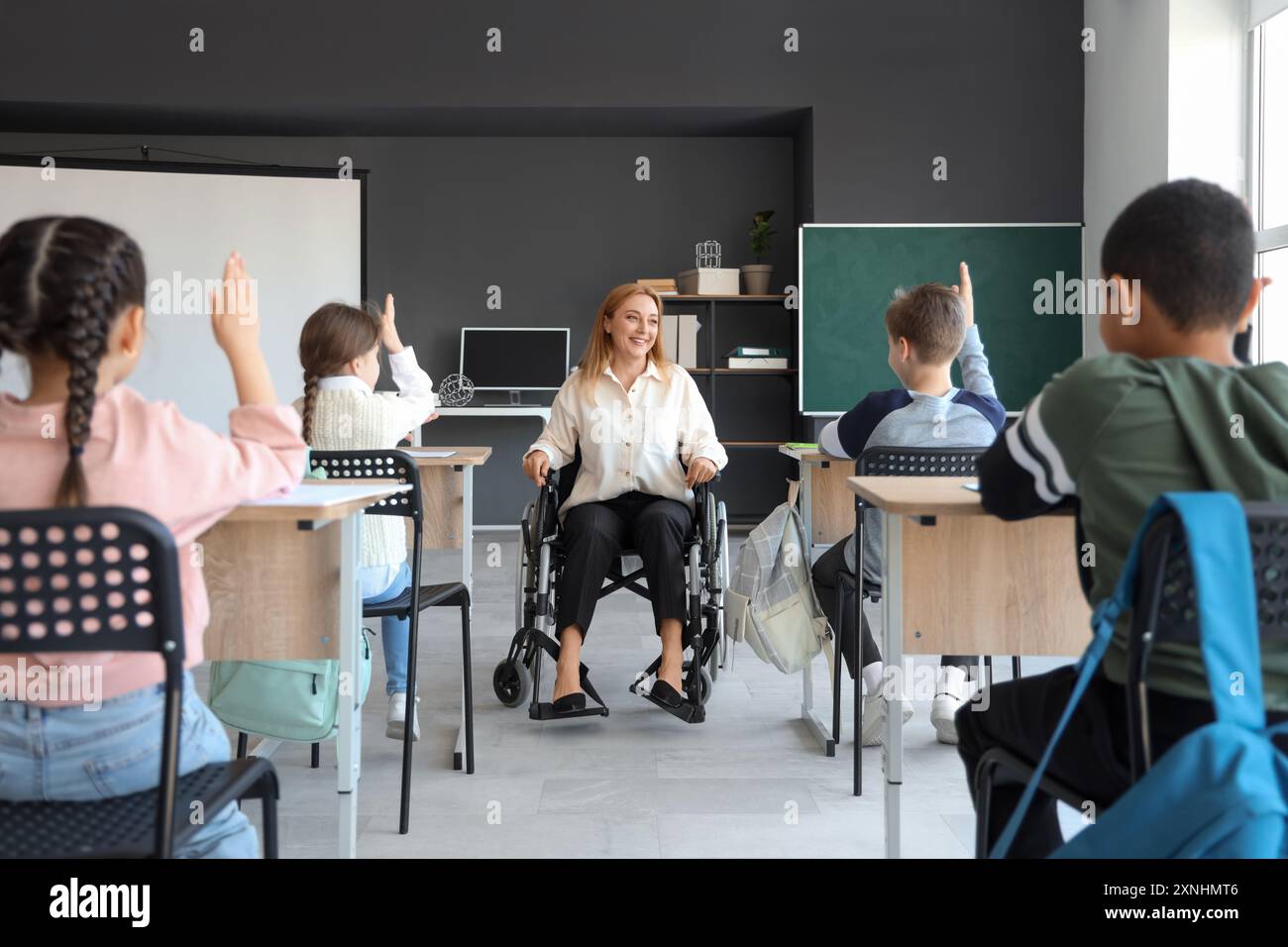 Mature teacher in wheelchair conducting lesson at school Stock Photo ...